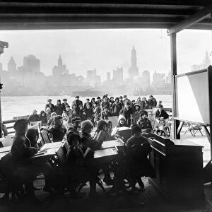 An open-air class on board a New York City ferryboat designated to provide day care for children with tuberculosis. Photograph, 1911