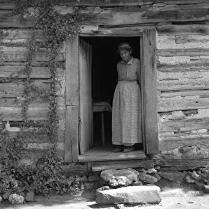 SHARECROPPER, 1939. A wife of a sharecropper standing in the kitchen doorway of