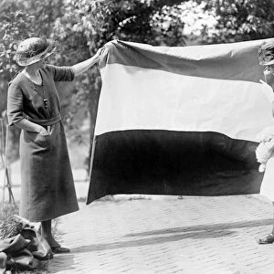 SUFFRAGETTES, c1915. Two suffragettes show their banner to a young girl. Photograph