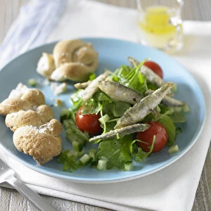 Fried whitebait on bed of green salad with tomato and bread rolls