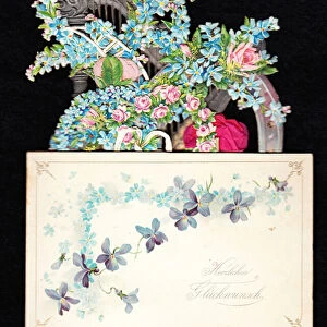 A Victorian die cut pop up greeting card of a harp entwined with forget-me-nots and roses