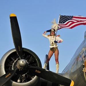 1940s style majorette pin-up girl on a B-17 bomber with an American flag
