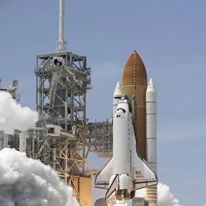 Atlantis twin solid rocket boosters ignite to propel the spacecraft into orbit at