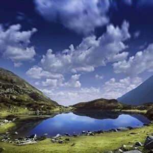 Blue lake in the Pirin Mountains over tranquil clouds, Pirin National Park, Bulgaria
