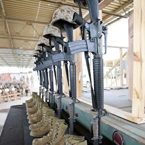 Boots, rifles, dog tags, and protective helmets stand in solitude to honor fallen