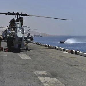 Captains perform pre-flight checks on an AH-1W Super Cobra