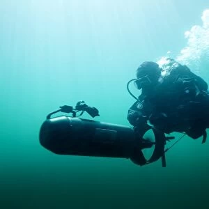 Combat diver navigates the waters using a diver propulsion vehicle
