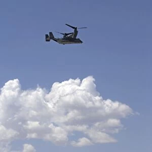 A CV-22 Osprey flies over a C-130 Hercules