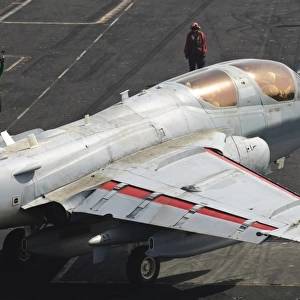 An EA-6B Prowler is guided onto a catapult aboard USS Harry S. Truman