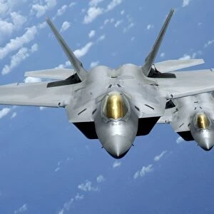 Two F-22 Raptors fly over the Pacific Ocean
