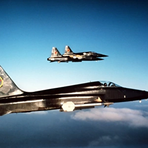 Three F-5E Tiger IIs in flight above the Pacific Ocean