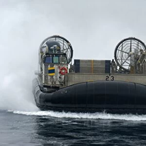 A landing craft air cushion approaches the well deck of USS New Orleans