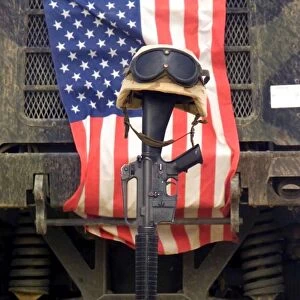 An M16-A2 service rifle, a pair of boots and a helmet stand in tribute to a fallen