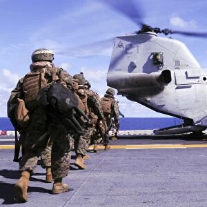 Marines board a CH-46E Sea Knight helicopter aboard USS Essex