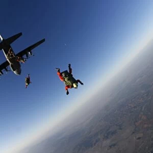 Several military freefall parachutist course students exit an aircraft