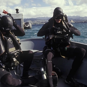 Navy SEALs combat swimmers donn their equipment in a utility boat