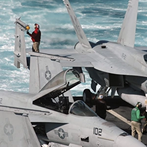 Ordnancemen perform checks on a F / A-18E Super Hornet aircraft