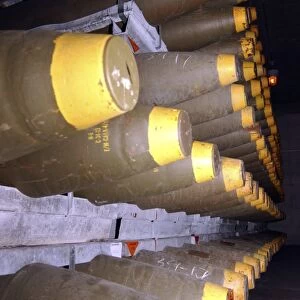 Racks of bombs sit inside the interior of a warehouse