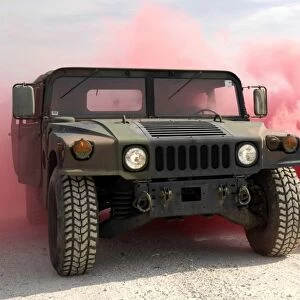 Red smoke billows out onto a humvee