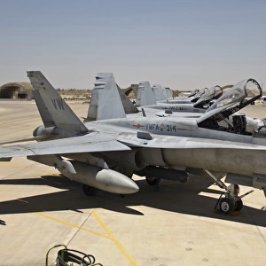 A row of U. S. Marine Corps F-18 Hornets await post-flight maintenance