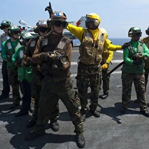 Sailors fight a simulated fire drill on the flight deck of USS Enterprise