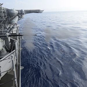 Sailors fire a 25mm machine gun aboard USS Bonhomme Richard