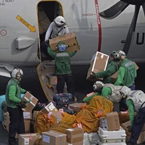 Sailors load mail on to a C-2A Greyhound