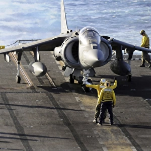 Sailors prepare to launch an AV-8B Harrier during flight operations aboard USS Peleliu