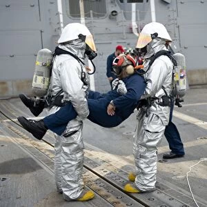 Sailors simulate rescuing a pilot during a crash and salvage drill