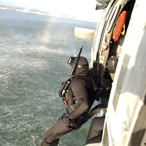 A search and rescue swimmer student jumps from a MH-60S Knighthawk