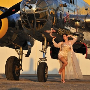 Sexy 1940s pin-up girl in lingerie posing with a B-25 bomber