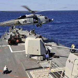 An SH-60B Sea Hawk helicopter picks up a pallet from USS Jason Dunham