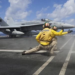 Shooters give the signal to launch an F / A-18C Hornet