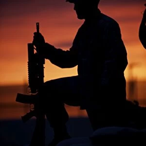 Silhouette of a U.s Marine on a bunker at sunset in Afghanistan