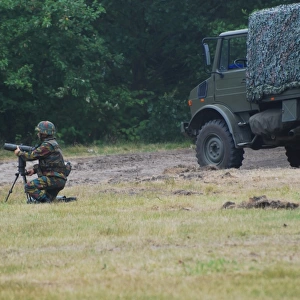 A soldier of the Belgian artillery unit sets up a device toAguide howitzer units