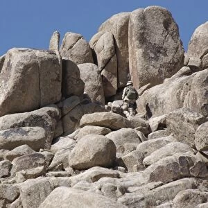 A soldier climbs a mountain