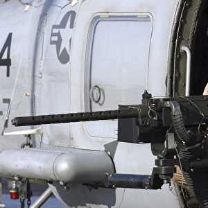 Soldier mans a. 50 caliber machine gun on an SH-60 Seahawk