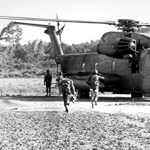 Soldiers run to a HH-53C helicopter during an asualt on Koh Tang Island