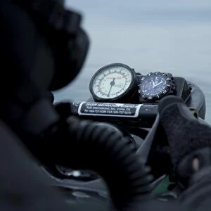 Special operations forces combat diver checks the depth gauge on his compass