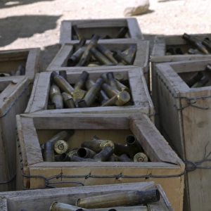 Spent. 50-caliber machine gun shell casings sit inside wooden boxes