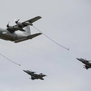 A Swedish Air Force C-130E Hercules with two Czech Air Force Gripens in tow