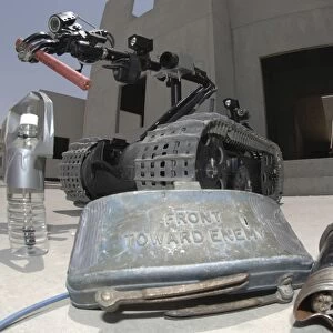 A Talon 3B robot recovering a stick of dynamite and other explosive devices in Bahrain