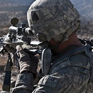 U. S. Army sniper scans a village in Afghanistan for Taliban activity