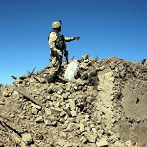 A U. S. Army Soldier examines the rubble of a destroyed compound