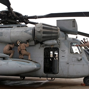 U. S. Marines perform preflight checks on a CH-53E Super Stallion helicopter