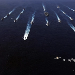 U. S. Navy aircraft fly over a formation of U. S. and Japanese ships