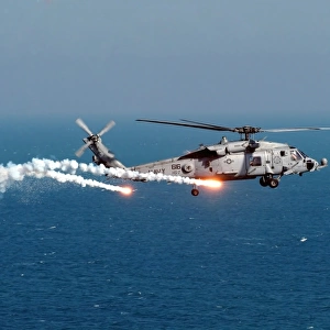 A U. S. Navy HH-60H Seahawk Helicopter dispenses flares and chaff