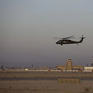 A UH-60 Blackhawk helicopter flies past the tower on Camp Speicher