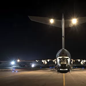 An RAF Chinook helicopter is loaded into a C-17 Globe master