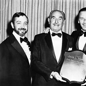 Frank Sinatra with friends holding a shield to tribute the Warner Brothers